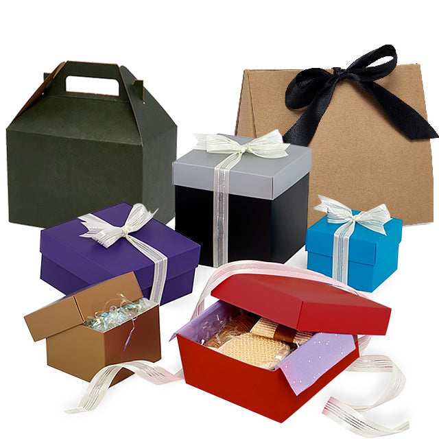 A collection of colorful gift boxes and packaging bags shown on a white background, including a dark green handle box, a kraft paper bag with a black ribbon, a gray box with a white ribbon, a purple box with a white ribbon, a blue box with a white ribbon, and an open red box containing a pastry.